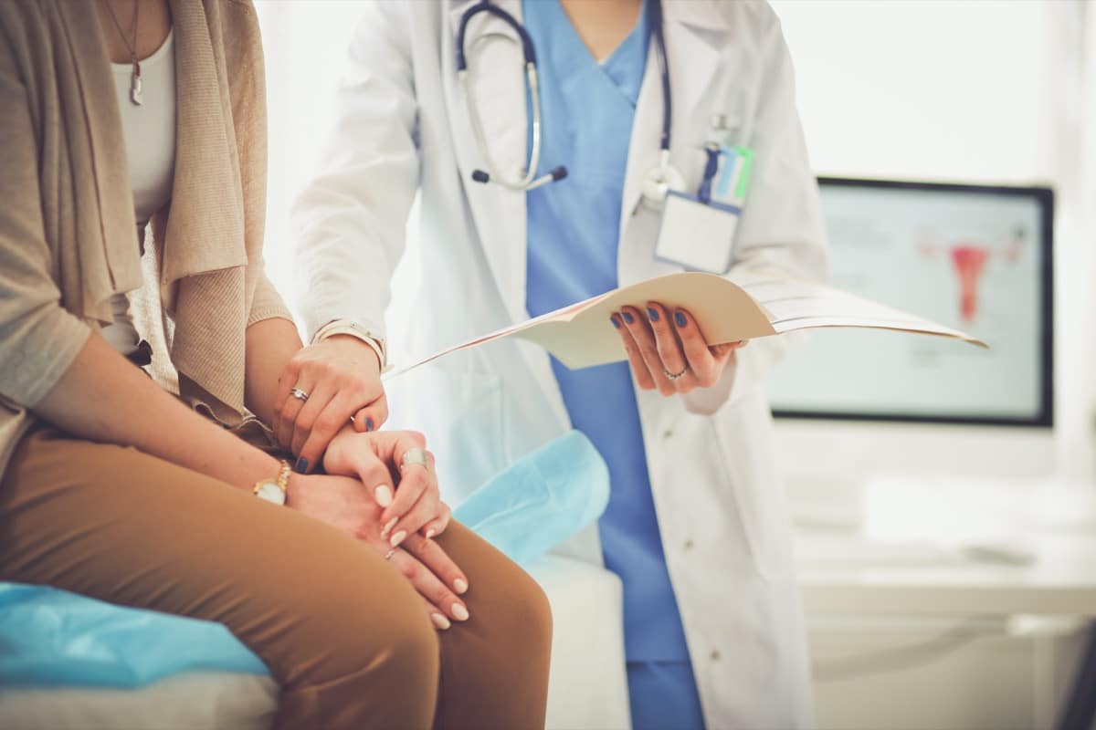 Doctor and patient discussing something while sitting at the table . Medicine and health care concept. Doctor and patient