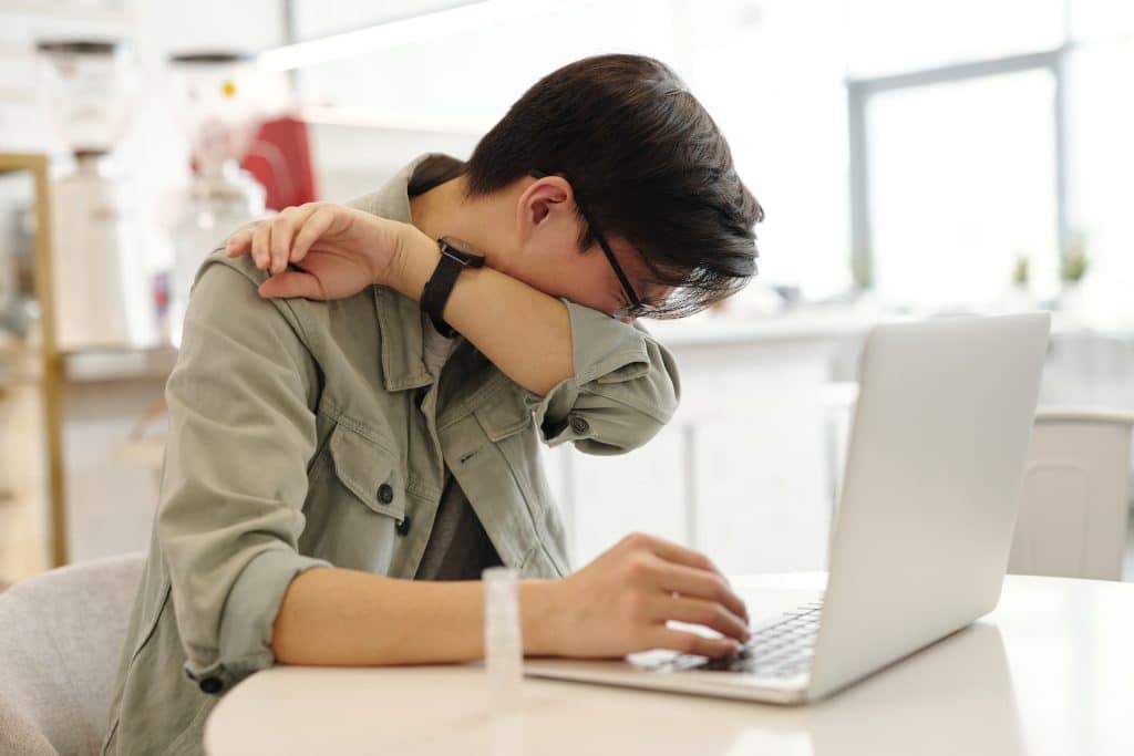 Un uomo che lavora al Pc soffre di una forte influenza