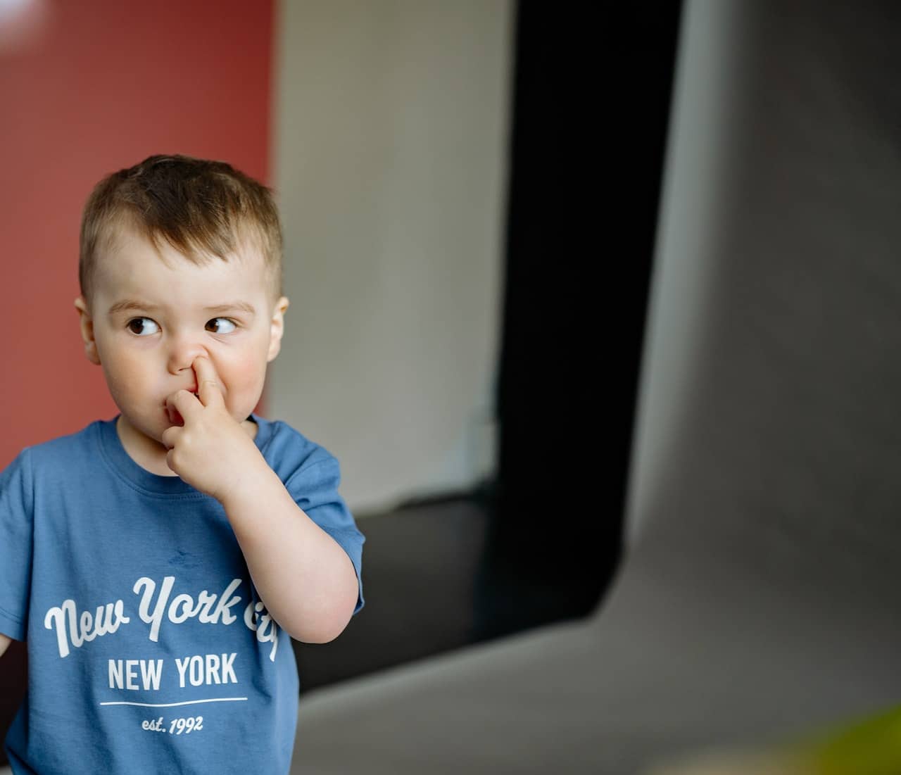 Bambino con le dita nel naso