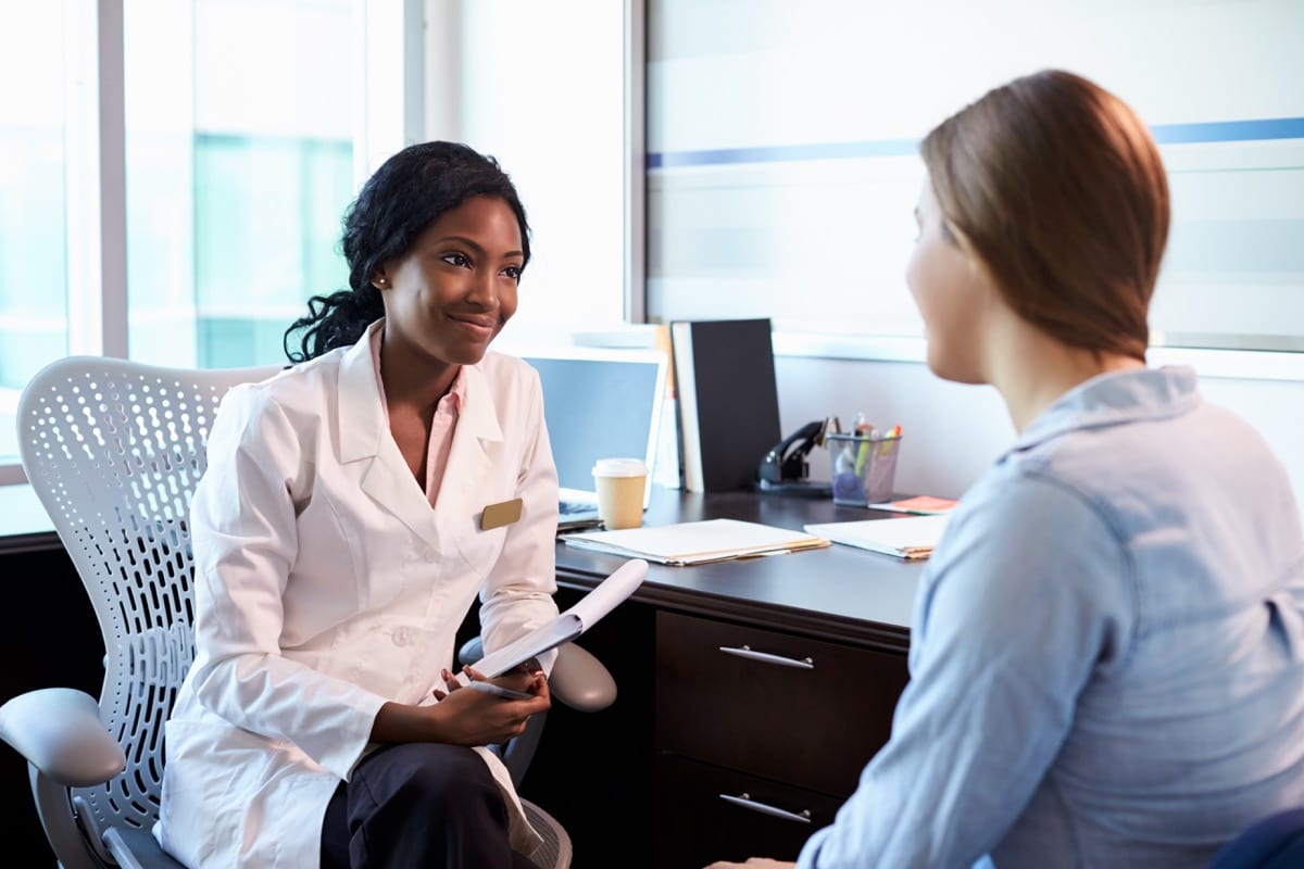 Doctor In Consultation With Female Patient In Office